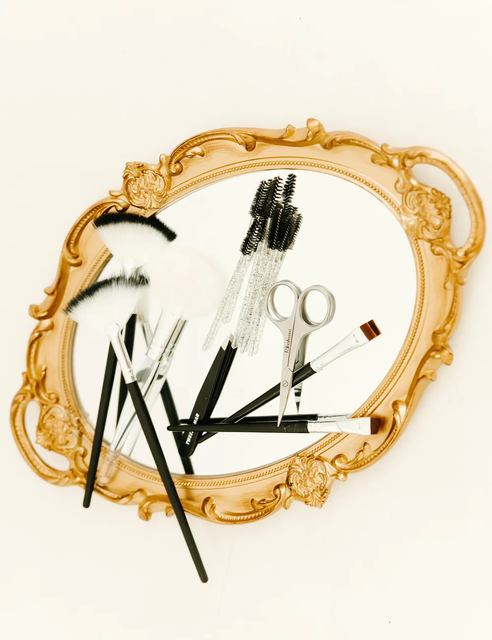 Beauty tools arranged on a gold mirror