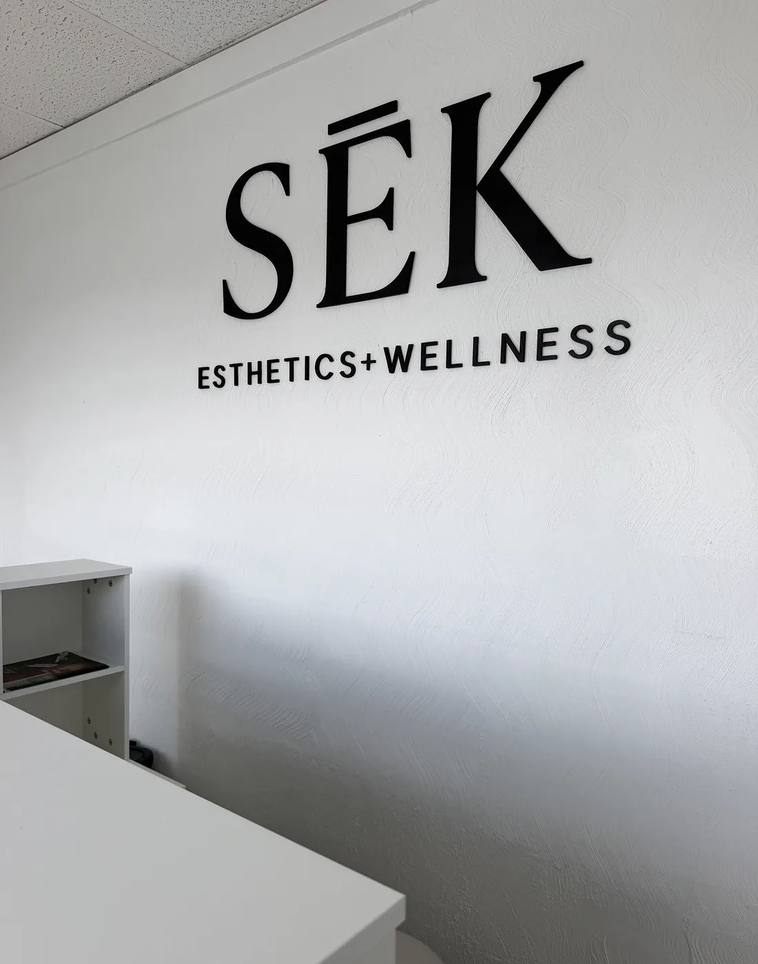 SĒK Esthetics + Wellness logo wall